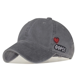 Detail of dark grey washed cotton baseball cap with red heart and OOPS embroidery