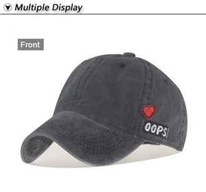 Detail shot of vintage washed grey cotton baseball cap with red heart and OOPS embroidery