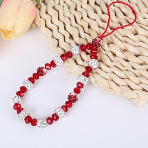 Close-up of red beaded phone charm with crystal-studded silver beads and floral pendant