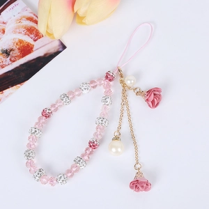 Detailed shot of beaded phone charm with pink fabric roses and gold-toned floral accents