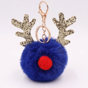 Close-up of plush reindeer keychain with sequins antlers and navy blue pom pom