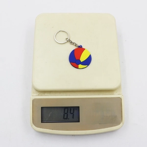 Colorful PVC beach ball keychain on an electronic scale showing 8.4g weight