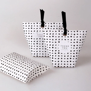 Detailed view of polka dot gift bags with black ribbons and Thank You stickers