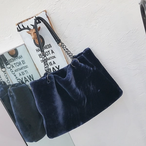 Detailed view of the dark blue faux fur tote bag with metal chain and leather strap