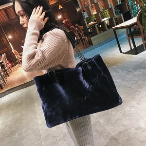 Detail of plush faux fur texture on a large navy blue tote bag with metal chain strap