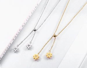Detailed view of daisy pendants in gold and silver with zircon centers on Y-necklaces