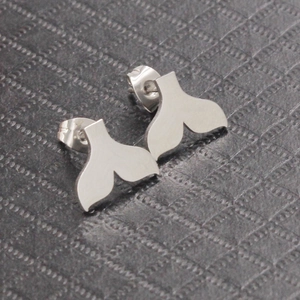 Detailed close-up of silver mermaid tail stud earrings with butterfly backings