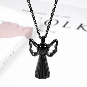Close-up of black angel wing cremation urn necklace on a lifestyle background