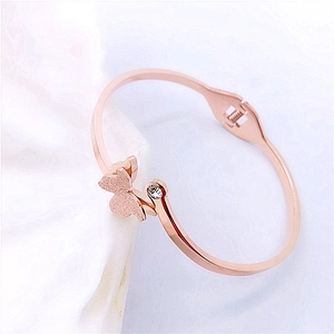 Detail of rose gold butterfly bangle with crystal inlay and secure side clasp closure