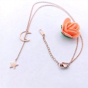 Detail of rose gold moon and star necklace with adjustable lobster clasp on white background