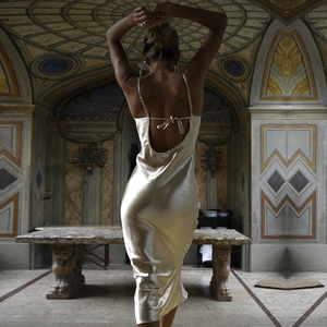 Vue détaillée du dos d'une robe de soirée en satin champagne dans un palais luxueux