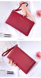 Deep red long wallet with pebbled texture and wristlet shown with elegant props