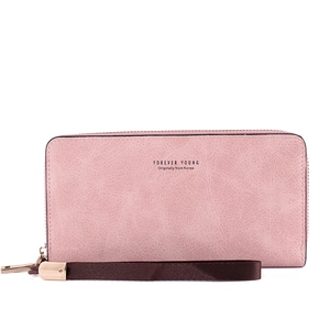 Pink faux leather long wallet with zipper closure and dark brown wrist strap on white background