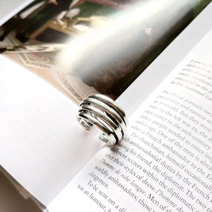 Macro shot of 925 sterling silver multi-layer line ring on an open English magazine