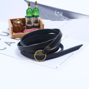 Detail of multi-layer black leather bracelet with gold D-ring buckle on vintage props
