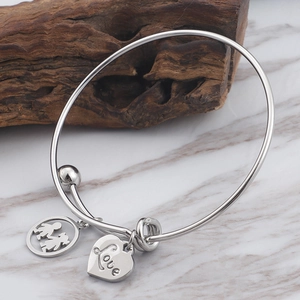 Silver LOVE titanium steel adjustable bracelet with heart and figure charms on marble background