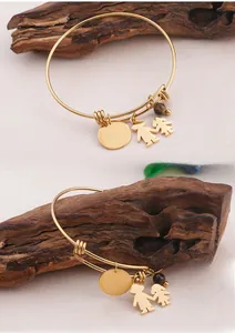 Macro detail of gold adjustable bracelet with I Love You Mom pendant and tiger eye bead