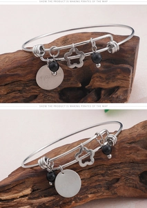 Detail of MOM love you engraved round tag and hollow flower charm on silver bracelet