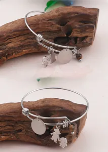 Macro detail of silver adjustable wire bracelet with tiger eye bead and Mom pendant