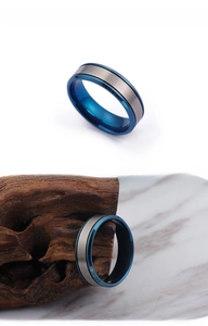 Detail of blue and silver brushed titanium ring shown on white and marble background