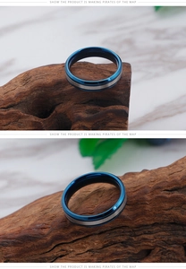 Macro shot of blue and silver dual-tone titanium steel rings on dark wood block