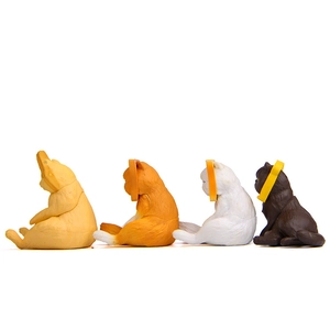 Row of four colorful plastic cat figurines with yellow collars on a clean white background