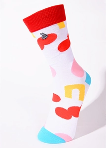 Close-up of white cotton mid-calf socks featuring colorful abstract geometric patterns