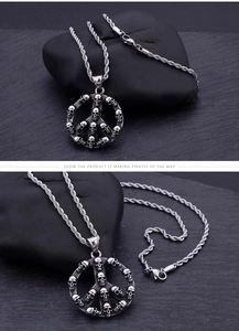 Close-up of retro punk skull peace sign pendant with detailed silver rope chain