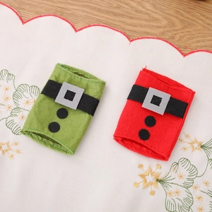 Christmas themed cutlery holders in red and green felt with belt design on wood table
