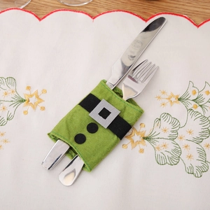 Green felt Christmas elf cutlery holder with black belt detail on white embroidered mat