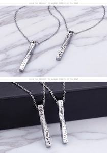 Détail de pendentifs barre torsadée argentée avec texture gravée sur marbre et cuir noir