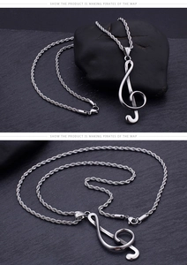 Macro shot of silver treble clef music note pendant with stylish rope chain