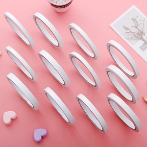 Set of 12 rolls white double-sided adhesive tapes on a pink decorative background