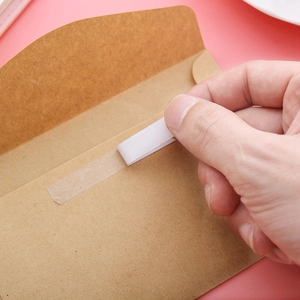 Strong 8mm double-sided adhesive tape roll used on a kraft envelope for office work