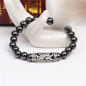 Bracciale di perle nere da 8mm con tubo in metallo argentato su un supporto in ceramica