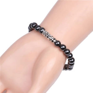 Dettaglio di perle magnetiche nere da 8 mm e tubo d'argento inciso su un bracciale