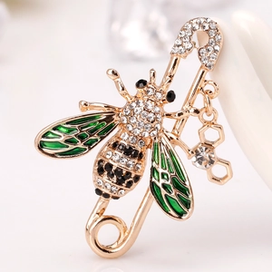 Golden bee brooch with black rhinestones and green enamel wings on safety pin base