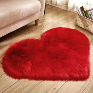 Plush heart-shaped red faux fur rug on light wood floor for cozy bedroom decor