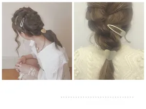 Detail of matte gold heart hair tie and oval clip styled in an elegant braided ponytail