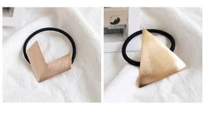 Detailed macro view of brushed gold triangle and rose gold V-shaped metal hair ties