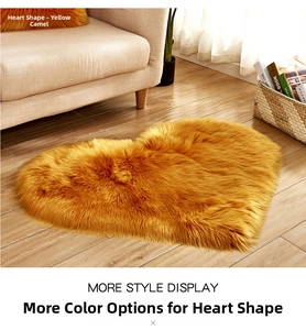 Detail of soft heart-shaped shaggy rug in yellow camel color on wooden floor