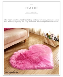 Detail of rose red heart-shaped plush rug on wooden floor with soft home interior lighting