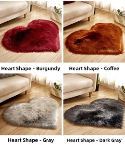 Detail view of heart-shaped plush rugs in burgundy, coffee, gray and dark gray colors