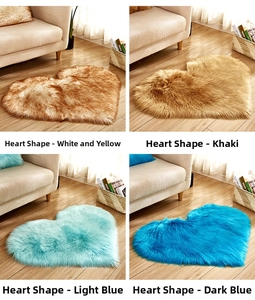 Close-up of soft heart-shaped plush rugs in white, khaki and blue on wood floor