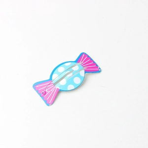 Detail of blue candy-shaped BB hair clip with white polka dots and pink accents