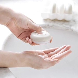 Portable lotion dispenser set with press-pump design and white donut-shaped bottles