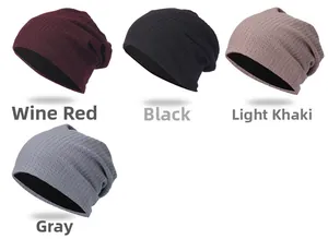 Dettaglio di berretti in maglia a nido d'ape nei colori bordeaux, nero e grigio