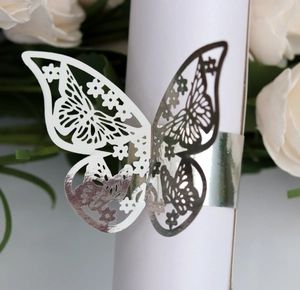 Macro shot of a silver laser-cut butterfly napkin ring with fine镂空hollow patterns