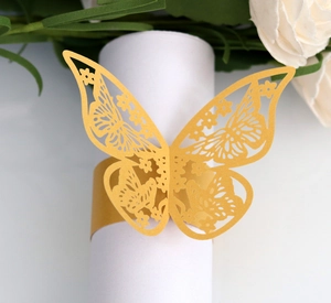 Detail of laser-cut butterfly napkin ring in yellow on white rolled napkin