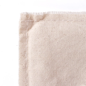 Macro shot of natural beige cotton canvas fabric showing texture and stitching details